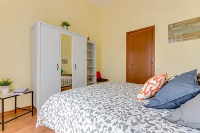 a bedroom with a large bed with blue pillows at Alice House al Vaticano in Rome