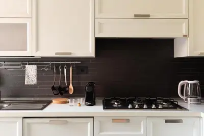 a kitchen with white cabinets and a stove top at Appartamento Elegante e Luminoso con Metro Vicina in Rome