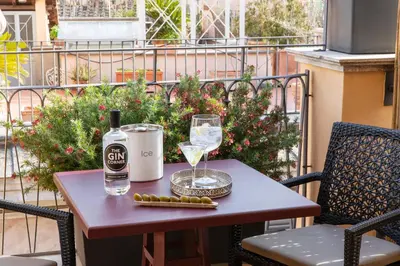 a table with a bottle of wine and a glass at HOTEL ADRIANO Rooftop in Rome