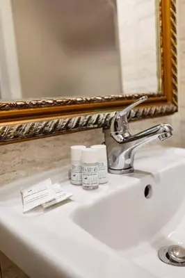 a bathroom sink with a toothbrush and a mirror at Appartamento Moderno nel Cuore di Roma in Rome