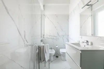 a white bathroom with a toilet and a sink at San Pietro Appartamento Luminoso e Moderno in Rome