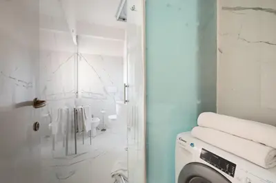 a white bathroom with a washing machine in it at San Pietro Appartamento Luminoso e Moderno in Rome