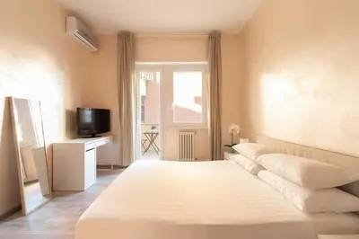 a bedroom with a large white bed and a television at San Pietro Appartamento Luminoso e Moderno in Rome