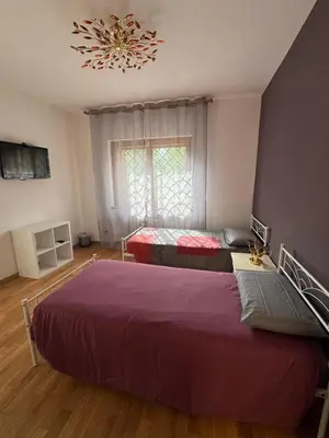 a bedroom with two beds and a chandelier at Villa Domus Roma in Rome