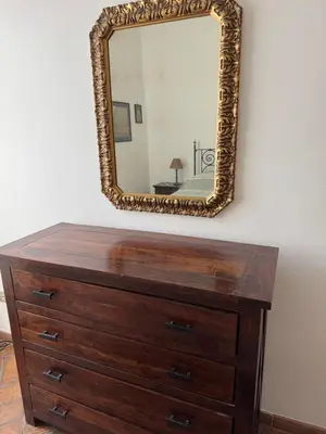 a mirror on the wall above a dresser at Borgo in Elegante appartamento in Rome