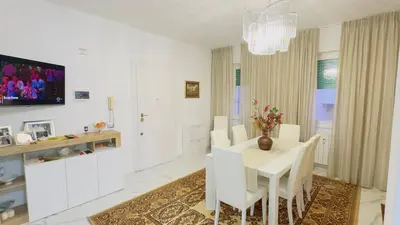 a white dining room with a white table and white chairs at Marconi House - A un passo da Trastevere in Rome