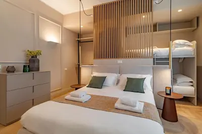 a bedroom with a large white bed with two bunk beds at Cipro Vatican Luxury Escape in Rome