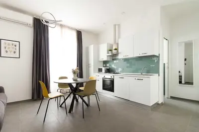 a kitchen with white cabinets and a table and chairs at Gilda's Home in Rome