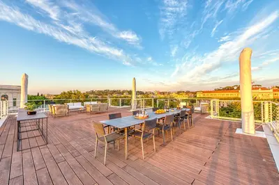 a patio with a table and chairs on a deck at Skylife 360 Rooftop Penthouse in Rome