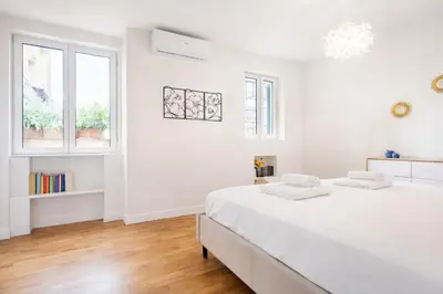 a white bedroom with a bed and a window at Elegantis Monti Royal Apartment with private terrace in Rome