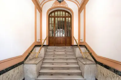 a staircase leading to a wooden door in a building at Paramount Penthouse in Rome