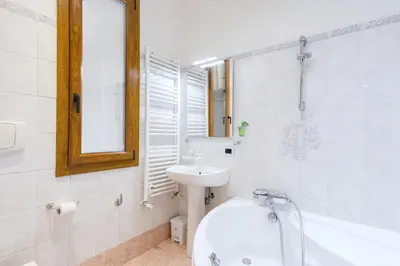 a bathroom with a sink and a toilet and a tub at Elegantis San Giovanni Suite - Chic Apartment with Bathtub Near Historic Center, Metro & Tram Nearby in Rome