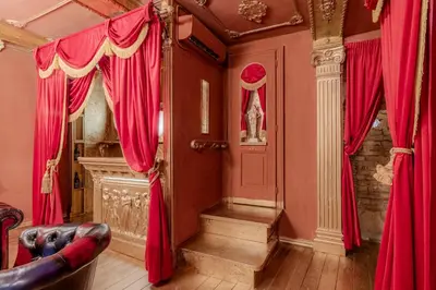 a living room with red drapes and a staircase at Villino Ermes Campanelli in Rome