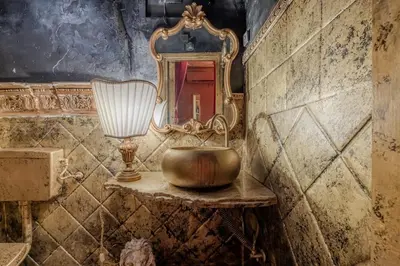 a bathroom with a gold sink and a mirror at Villino Ermes Campanelli in Rome