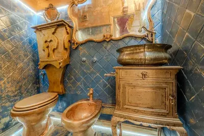 a bathroom with a copper toilet and a wooden cabinet at Villino Ermes Campanelli in Rome