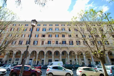 a large building with cars parked in front of it at HC - Piazza Vittorio Emanuele Dream in Rome