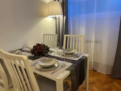 a white table with chairs and a table with wine glasses at Cozy Donatello Apartment in Rome