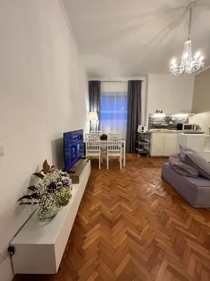 a living room with a couch and a table at Cozy Donatello Apartment in Rome