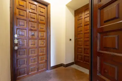 a hallway with wooden doors in a house at Domus Caroli in Vaticano in Rome