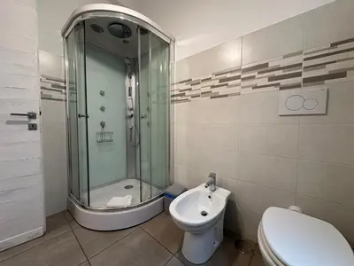 a bathroom with a shower and a toilet and a sink at Le Crete Apartment in Rome