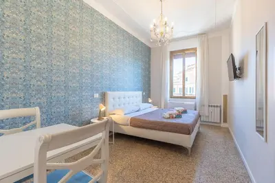 a bedroom with a bed and a blue wall at B&B Floret Roma San Giovanni in Rome