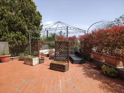 a garden with a greenhouse and benches and plants at La Terrazza del Poeta in Rome
