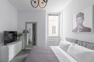 a white bedroom with a bed and a television at Trastevere Modern 4BR 4baths, WIFI, AC, custom kitchen, living room in Rome