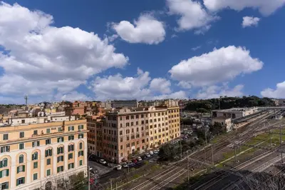 an aerial view of a city with buildings and clouds at Amazing Piramide Metro Station in Rome