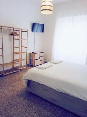 a bedroom with a bed and a tv and shelves at Domus Remo Room #2 in Rome
