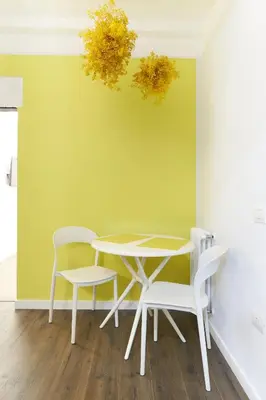 a table and chairs in a room with a green wall at RipettArt Apt in Rome