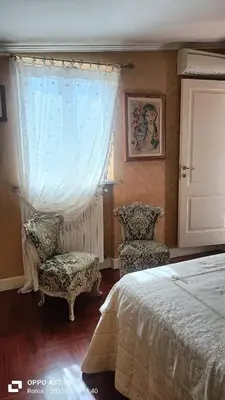 a bedroom with a bed and two chairs and a window at Terrace of the Aureli in Rome