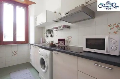 a kitchen with a washing machine and a microwave at Holy Vatican Home in Rome