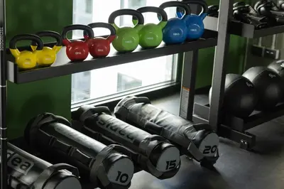 a gym with weights and dumbbells on a shelf at The Social Hub Rome Extended Stay in Rome