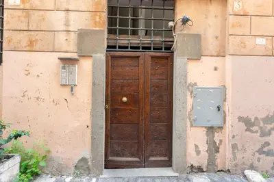 an old wooden door in the side of a building at Trastevere 2 Badrooms Design Appartment in Rome