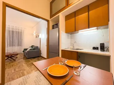a kitchen with a wooden table with orange plates on it at Braliu Apartment in Rome