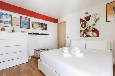 a bedroom with a white bed and a red wall at Hostly-Salotti Terrace Suite-20min to Vatican in Rome
