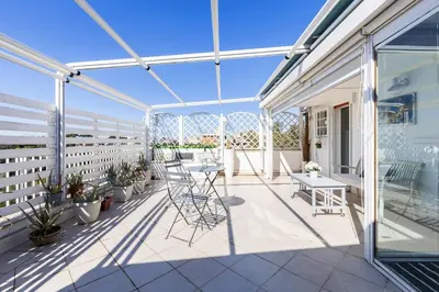 a balcony with chairs and tables on a house at Hostly-Salotti Terrace Suite-20min to Vatican in Rome