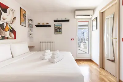 a bedroom with a white bed with towels on it at Hostly-Salotti Terrace Suite-20min to Vatican in Rome