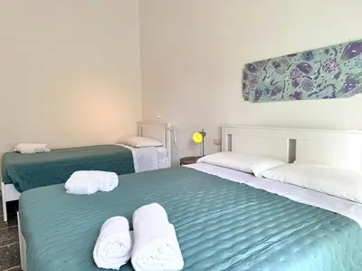 two beds in a room with towels on them at La Dolce Vita - Roman Experience in Rome