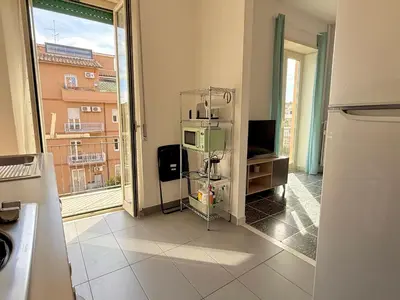 a kitchen with a room with a microwave and a window at La Dolce Vita - Roman Experience in Rome