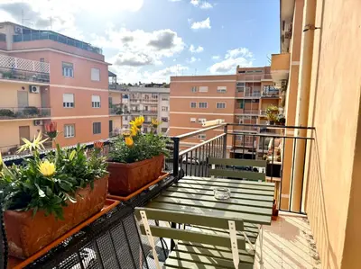 a balcony with two benches and flowers on a building at La Dolce Vita - Roman Experience in Rome