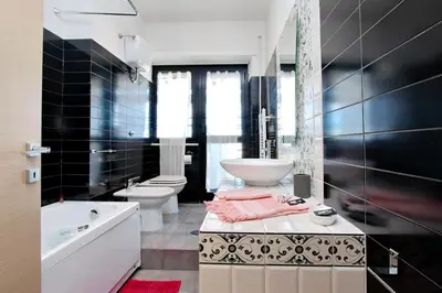 a black and white bathroom with two toilets and a sink at Monteverde Nuovo Penthouse in Rome