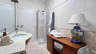a bathroom with a sink and a shower and a lamp at ALCAVE holiday home in Rome