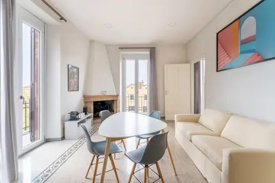 a living room with a couch and a table and chairs at La Galleria, Rooftop Flat Nearby Villa Borghese in Rome