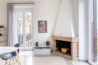 a living room with a brick fireplace and a table at La Galleria, Rooftop Flat Nearby Villa Borghese in Rome