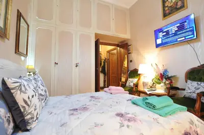 a bedroom with a bed with a tv on the wall at Casa Bianca room 16 in Rome