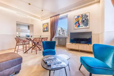 a living room with blue chairs and a flat screen tv at Gianicolo Suites in Rome