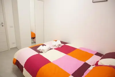 a bedroom with a colorful bed with two pillows at Sunny's Suite - 8min from Colosseum in Rome