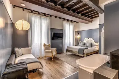 a bedroom with a bed and a tub in a room at Telier Ripetta in Rome