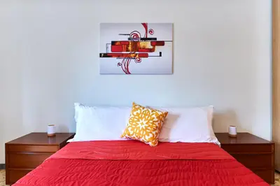 a bed with a red blanket and two pillows at 15 minuti da San Giovanni - A c, Wifi e Smart Tv in Rome